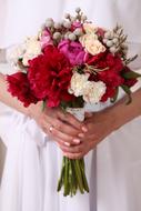 bouquet of colorful flowers in the hands of the bride