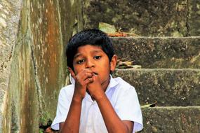 boy sitting on the stairs in sri lanka