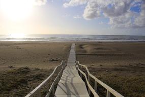 Beautiful landscape of the wooden path, among the colorful fields, on the beach, in sunlight
