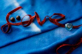 word love with red ribbon on blue fabric