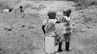 Black and white photo with the children of Uganda, among the plants