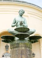 Beautiful fountain with the green sculpture, of the yellow building