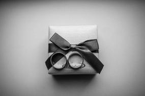 wedding rings on a gift box in black and white background