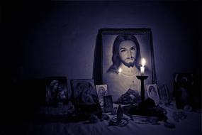 candle burning in front of home Altar