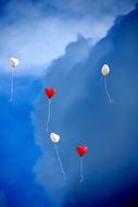 red and white heart shape Balloons at sky