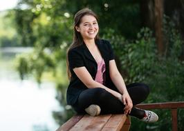 girl sitting near the river on a blurred background