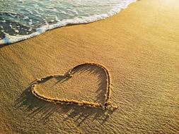 heart as a symbol of love on wet sand