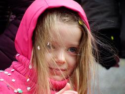 happy little girl in pink hood close up