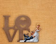 funny figurines of the bride and groom on the background of the word "love"