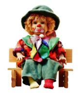 Colorful, sad clown, sitting on the wooden bench, at white background