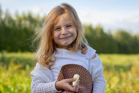 pretty caucasian child girl with banana in hand outdoor