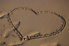 Beautiful heart painting on the sandy beach, in light