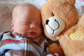 sleeping newborn with teddy bear