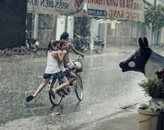 children cycling in the rain