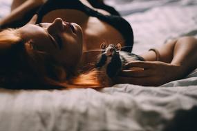 beautiful girl and black and white rat on the bed