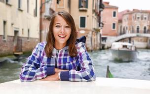 Smiling girl near the canal in beautiful Venice, Italy