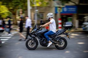man on motorcycle on city street in blurred background