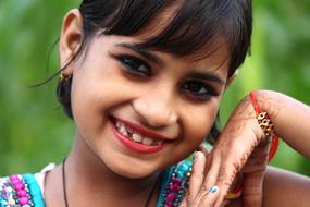 portrait of happy indian girl on blurred background