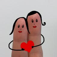 fingers with painted faces and a red heart