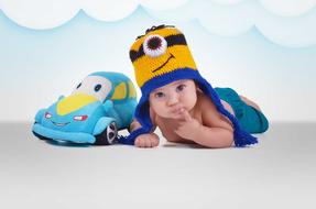 a little child next to a toy car