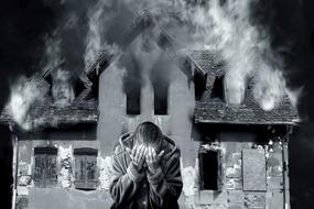 black and white photo of burning house Smoke and sad man