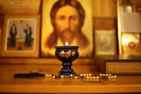 candle with beads near the icon in the church