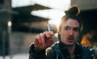 Smoker, young man with cigarette in fingers