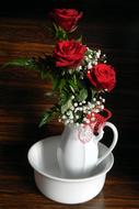 bouquet of red roses in a ceramic white jug