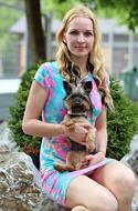 Portrait of the blonde woman in colorful dress with the beautiful, cute and colorful Yorkshire Terrier dog