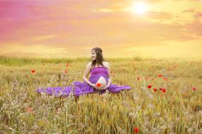 pregnant woman at a photo shoot on the field of poppies