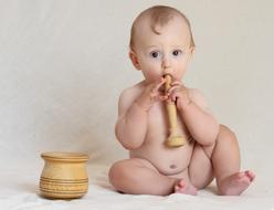 Portrait of the cute, blonde baby, with the beautiful, pattern mortar and pestle