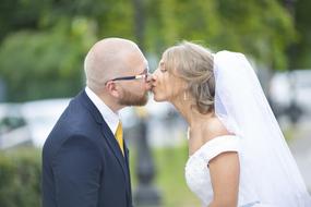 kiss of newlyweds on a blurred background