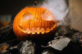 Orange Jack-O-Lantern, with the smoke, on the wood, on the Halloween