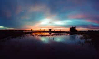 scenic sunset afterglow at sky mirroring on calm water