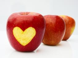 heart carved on side of red Apple