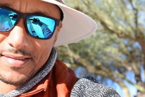 man in blue sunglasses close up on blurred background