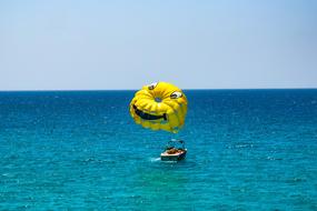 yellow parachutes is tied to a motor boat