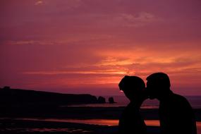 silhouette of couple kissing at sunset