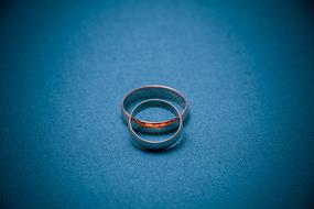 Close-up of the beautiful, shiny rings, on the turquoise surface, among the darkness