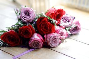 Beautiful bouquet of beautiful red and pink and white rose flowers on wooden surface