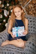 girl with a gift sitting in a chair