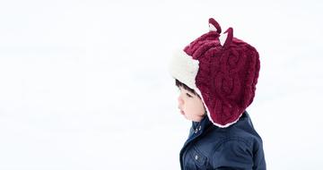 child in a warm hat in the snow