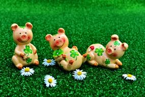 ceramic pigs with bite leaves on green grass