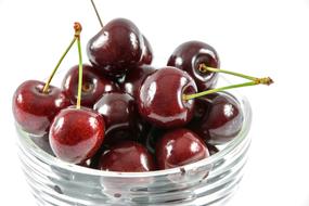 sweet cherries in a transparent bowl on a white background