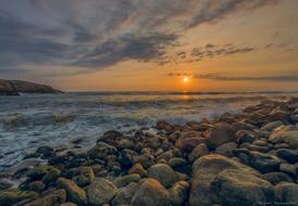 sunset over the rocky sea coast at dusk