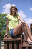 Smiling, sitting blonde teen girl with braces