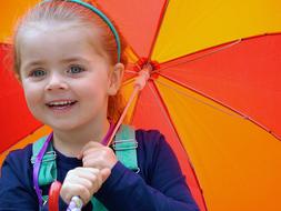 little girl posing with colorful umbrella