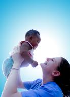 mom with newborn baby on the background of the sun