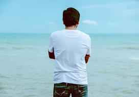 back view of man in white t-shirt at Ocean