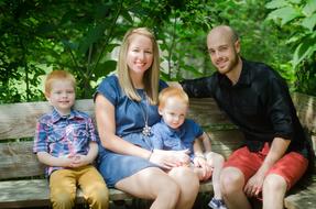 Happy family sitting on a park bench